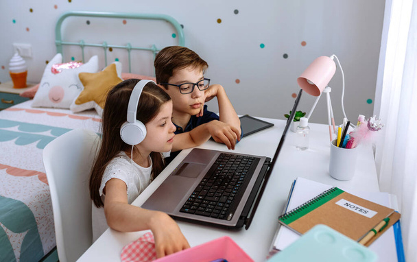 Хлопчик допомагає своїй сестрі навчатися з комп'ютером
 - Фото, зображення