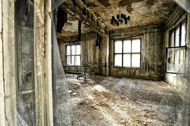 Opuszczony spalony salon restauracyjny z wybitymi szybami i zepsutą podłogą - Zdjęcie, obraz
