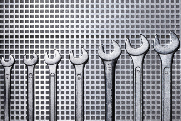 группа разного размера гаечных ключей с металлической сеткой с местом для копирования текста - Фото, изображение