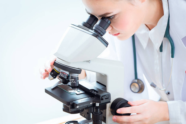 研究室でのウイルス研究のための科学研究室で顕微鏡を見る科学者. - 写真・画像