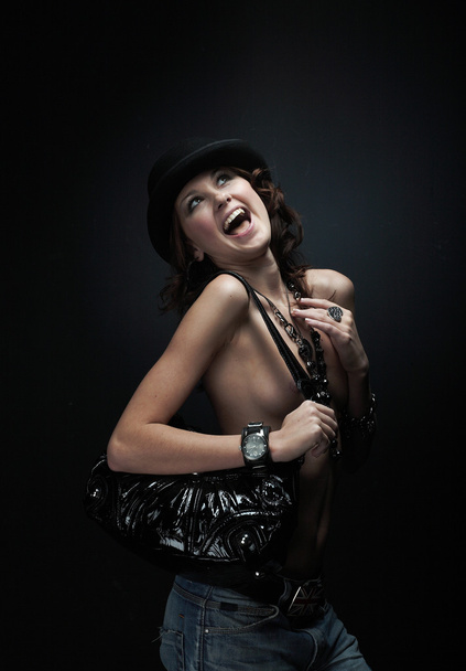 Beautiful young woman wearing black hat on black background - 写真・画像