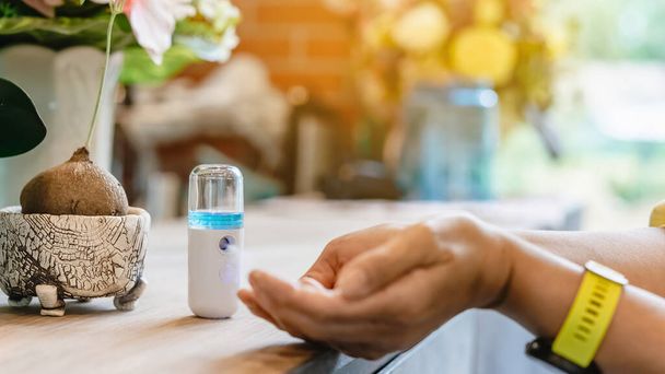 Ψεκαστήρας ομίχλης Nano Alcohol για καθαρισμό χεριών για την πρόληψη της εξάπλωσης του ιού Corona (Covid-19) για την εξυπηρέτηση πελατών στην καφετέρια. Σύγχρονη τεχνολογία υγείας. Νέος κανονικός τρόπος ζωής. Επιλεκτική εστίαση - Φωτογραφία, εικόνα