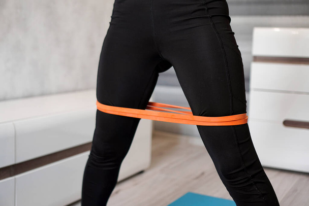 Woman during her fitness workout with rubber resistance band - Zdjęcie, obraz