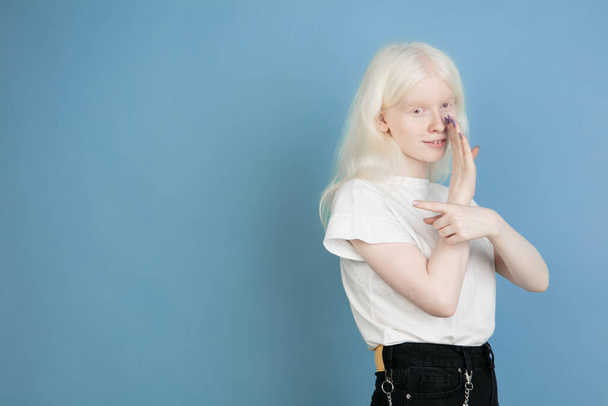 Portrait of beautiful caucasian albino girl isolated on blue studio background - Фото, изображение