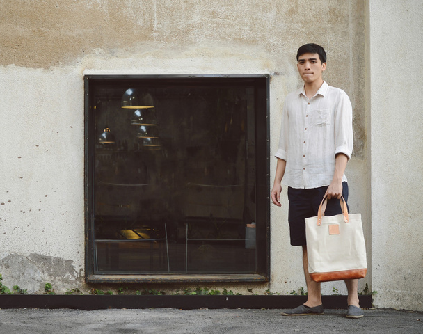Man with canvas bag on grunge concrete background - 写真・画像