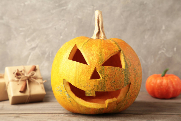 Halloween pumpkin with gifts on grey background. Top view - Φωτογραφία, εικόνα