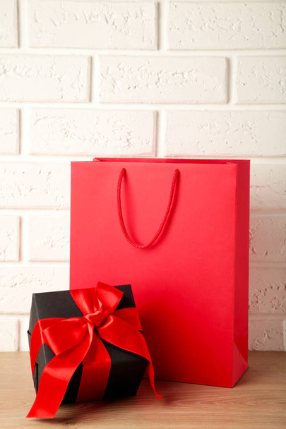 Red shopping bag with gift on light background. Black friday. Top view - Foto, immagini