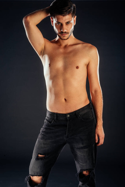 Attraktives junges männliches Model posiert oben ohne in schwarzen Jeans - Foto, Bild