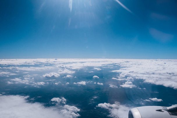 Υπέροχη θέα από ψηλά τα σύννεφα μέσα από ένα παράθυρο του αεροπλάνου - Φωτογραφία, εικόνα