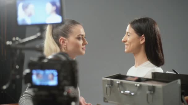 Maquillaje artista trabajando y haciendo vlog mientras se pone maquillaje a una chica - Metraje, vídeo