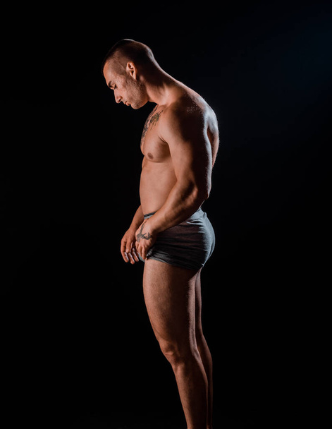 Sportos férfi tökéletes testtel edzés után elszigetelt fekete háttér. Erő és motiváció - Fotó, kép