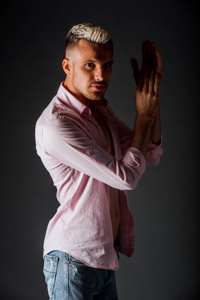 Persone e stile di vita. Attraente giovane maschio caucasico di buon umore, in camicia rosa a maniche lunghe - Foto, immagini