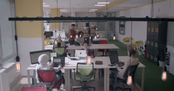 Jeunes de diverses origines ethniques travaillant dans un bureau moderne pendant la journée - Séquence, vidéo