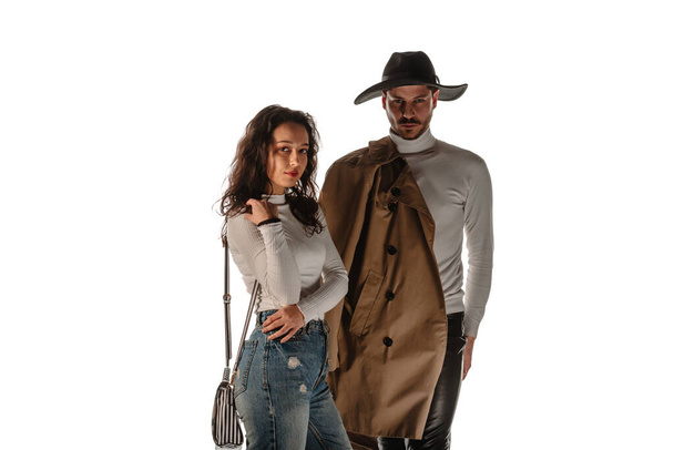 Body shot of a stylish fashion couple wearing modern style clothes over white wall - Foto, afbeelding