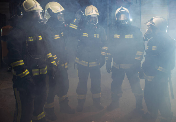Portrait d'un groupe de pompiers au milieu de la fumée de l'extincteur - Photo, image