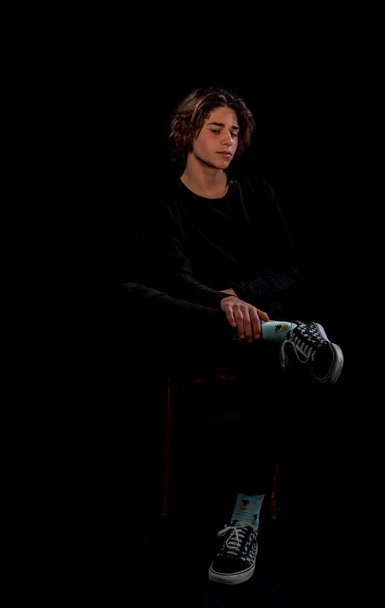 Современный молодой человек, одетый в модный свитер и джинсовые штаны - Фото, изображение