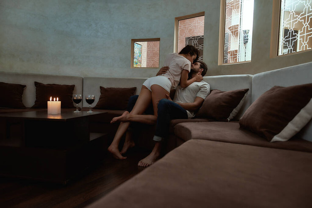 Temptation. Full-length shot of young sexy man and woman kissing before having sex on the couch - Fotografie, Obrázek
