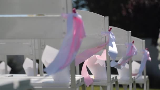 Wstążki kołyszą się na wietrze na krzesłach weselnych - Materiał filmowy, wideo