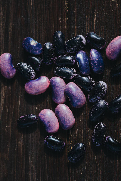 Pink and black beans on a wooden table - Foto, afbeelding