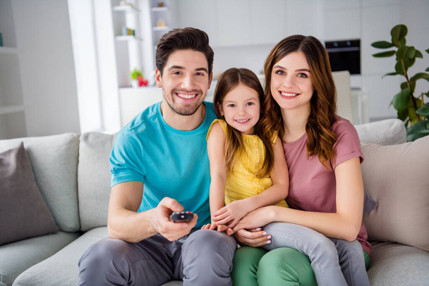 Photo of of dream support three people mom dad little kid girl sit comfort couch watch cartoon remote control switch in house indoors - Φωτογραφία, εικόνα