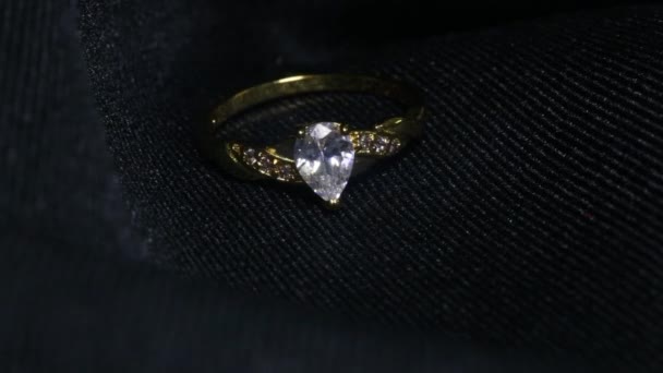 Экстремальные детали кольца с бриллиантом крупным планом на тёмном фоне. Обручальное кольцо было снято с помощью макрообъектива с неглубокой глубиной резкости. Концепция помолвки, брака и свадьбы - Кадры, видео