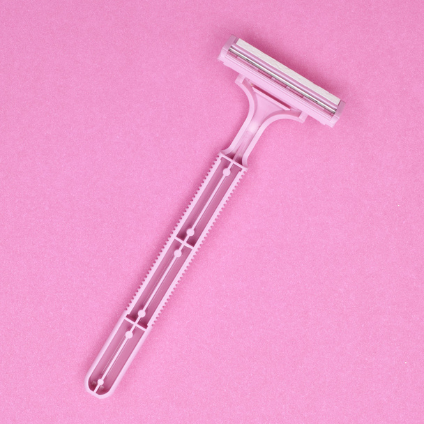 rózsaszín biztonsági borotvát, egy rózsaszín háttér. - Fotó, kép
