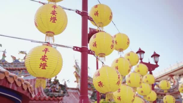 Некоторые желтые фонари с ярлыком благоприятных слов повесили трубку в храме Нань Кунь Шэнь Дай Тянь на Тайване. Красивые и украшенные здания окружены. - Кадры, видео