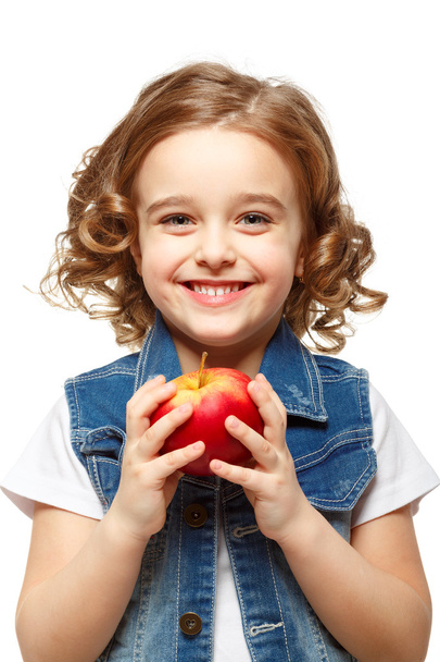 Pikkutyttö farkkutakissa, jolla on punainen omena. Eristetty w
 - Valokuva, kuva