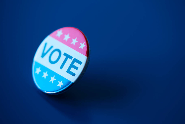 濃い青の背景を持つアメリカの選挙のための投票バッジの閉鎖、右側のいくつかの空白のスペース - 写真・画像
