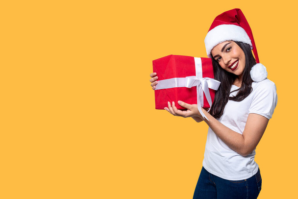 Santa Claus woman holding a gift, isolated on yellow background. - Photo, Image