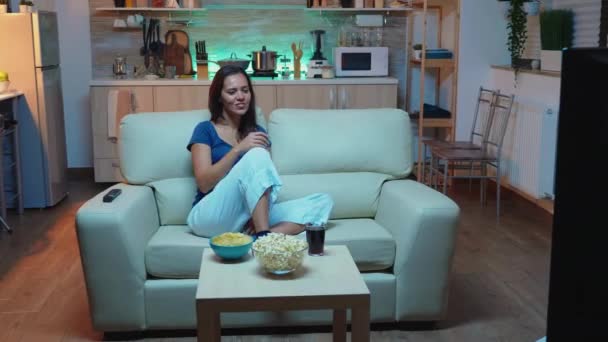 Γυναίκα κάθεται στον καναπέ βλέποντας ταινία - Πλάνα, βίντεο