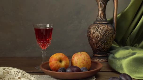 Натюрморт с бутылкой вина, яблок и слив. - Кадры, видео