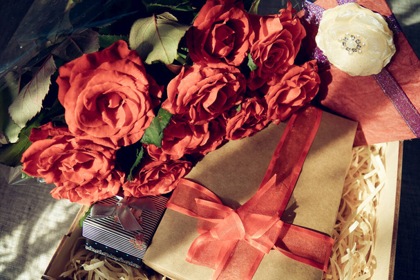 Box with a gift and a bouquet of red roses - Photo, Image