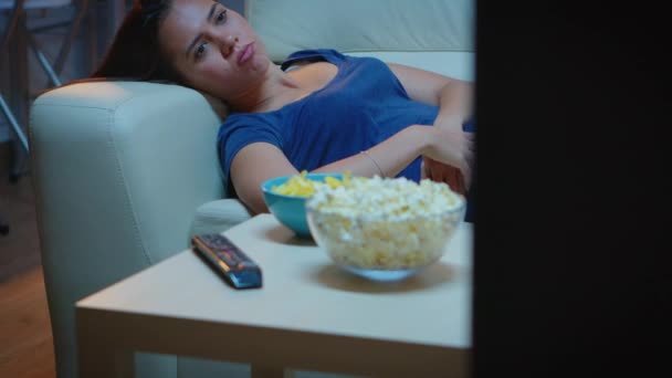 Wyczerpana kobieta ogląda program telewizyjny - Materiał filmowy, wideo