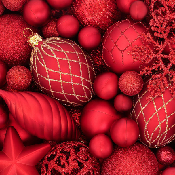 Rood-gouden glitter kerstversieringen vormen een abstracte achtergrond. Feestelijke wenskaart samenstelling voor de kerstvakantie seizoen. Vlakke lay, bovenaanzicht. - Foto, afbeelding