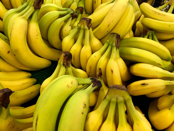 Macro foto producto alimenticio plátanos amarillos. Textura fondo plátanos tropicales maduros. Cáscara de plátano útil natural. - Foto, Imagen