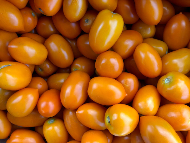 Makro-Foto Gemüse gelbe Tomaten. Archivbild Obst- und Gemüsetomaten liegen in Reihen. Illustration Hintergrund Gemüse von gelben Tomaten  - Foto, Bild