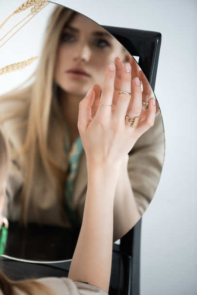 відображення жінки, яка торкається круглого дзеркала з розмитим переднім планом
  - Фото, зображення