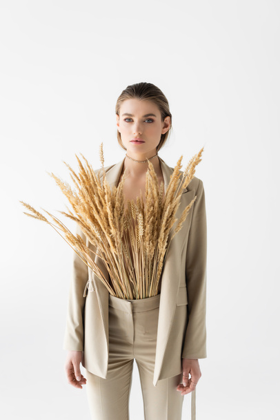 Stylisches Modell im beigen Anzug mit Weizenstacheln posiert isoliert auf weißem Grund  - Foto, Bild