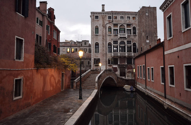Kanallı Venedik caddesi ve gece fenerlerinin ışığında bir köprü. Venedik 'in eski mimarisi. - Fotoğraf, Görsel