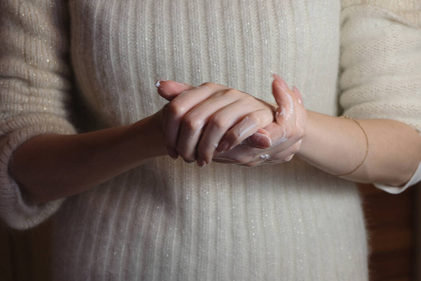 dívka klade vyživující krém na ruce - Fotografie, Obrázek