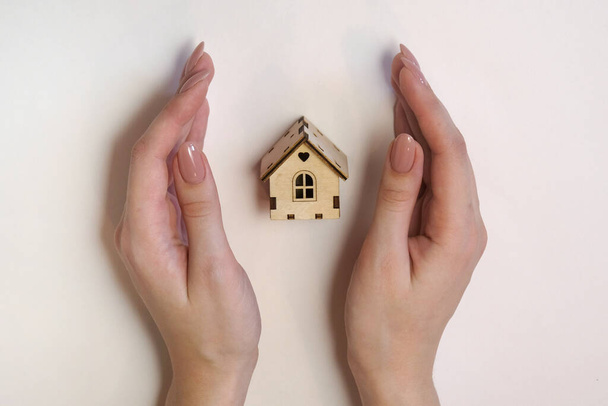 Model house in female hands on a light background - Photo, Image