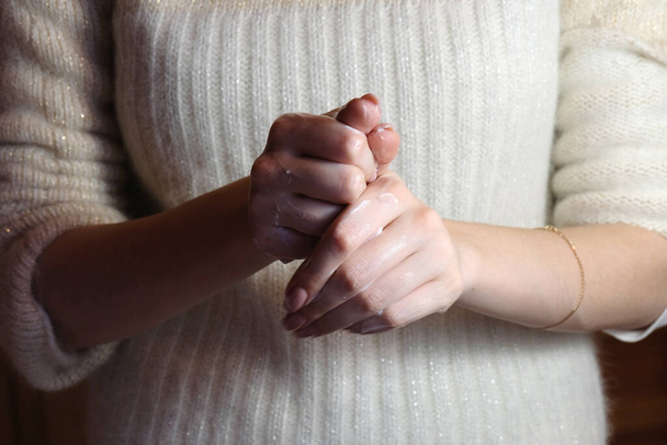 Η γυναίκα βάζει κρέμα στα χέρια της. έννοια φροντίδας χεριών - Φωτογραφία, εικόνα