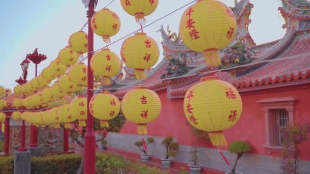 Eine Nahaufnahme mit der Kamera zeigt das Gehen an Laternen des Nan Kun Shen Dai Tian Tempels in Taiwan. Ein berühmter Tempel der asiatischen Kultur. Es gibt viele Laternen, Gebäude, Steinschnitzereien und Planeten in der Szene.   - Filmmaterial, Video