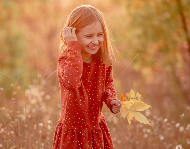 Happy little girl with yellow leaves - Fotografie, Obrázek