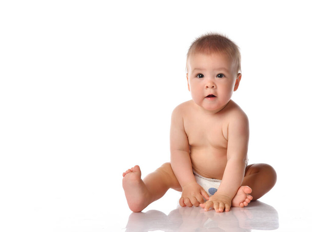Little baby in nappy on floor stretching out by hand - Фото, зображення