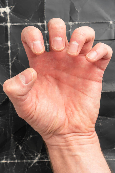Man clenching fist on black grunge background close up - Photo, Image