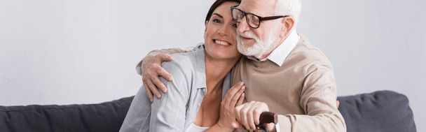 ηλικιωμένος άνδρας και κοινωνικός λειτουργός αγκαλιάζουν στο σπίτι, πανό - Φωτογραφία, εικόνα
