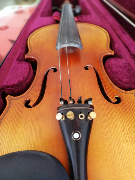 Скрипка и лук в темно-красном футляре. Закрыть - Фото, изображение