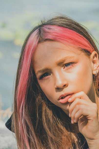 Portrét malé holčičky. Krásná dívka pózuje. Teenager, růžové vlasy. Adolescence koncept. Na fotce. Školačka ve věku 9 nebo 10 let - Fotografie, Obrázek